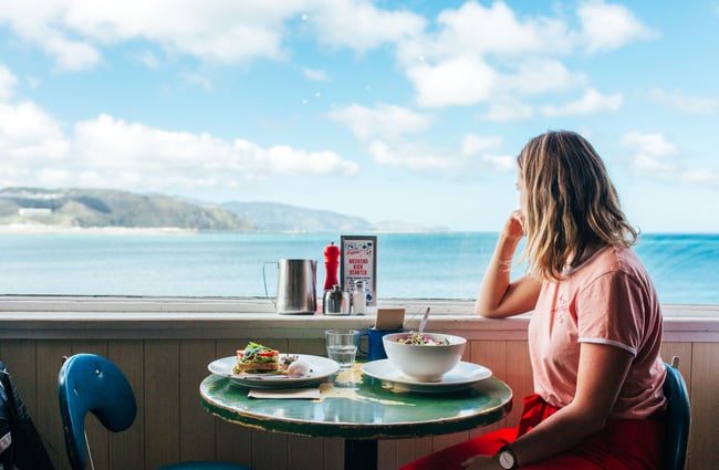 A girl sits in a cafe on the terrace and admires the view