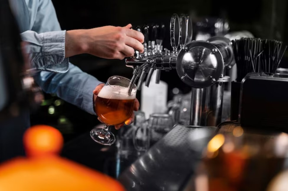 a hand pouring beer in a glass