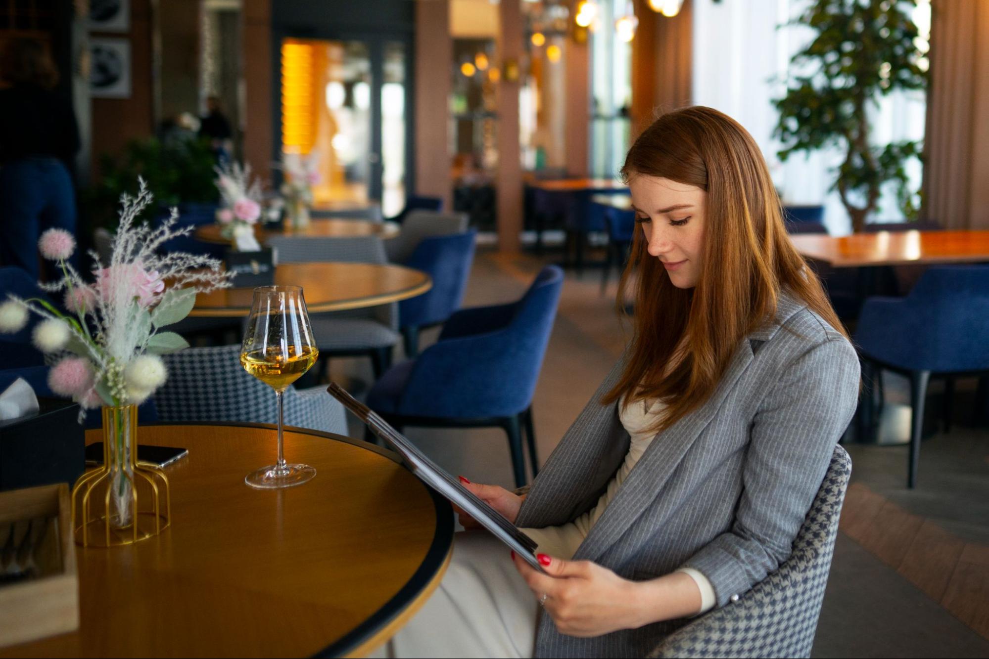 A woman at a restaurant looking at a menu